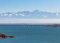 View of the Kapchagay reservoir with islands and a railway bridge against the backdrop of mountains in the Almaty region of Kazakhstan.